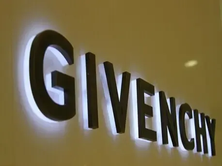 Gold reverse channel letters with warm halo glow on stone building facade