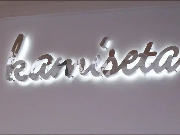 Black reverse channel letters with cool blue backlight on modern building