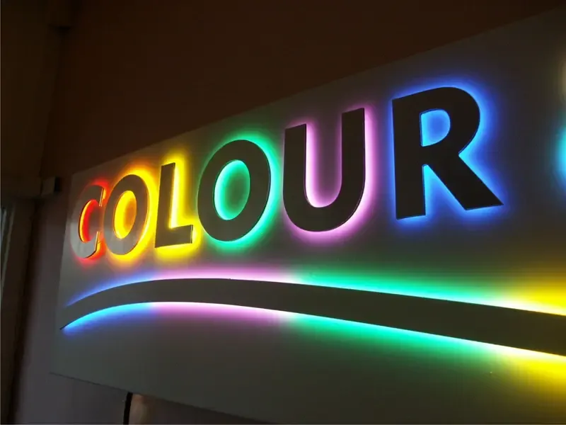 Brass halo lit letters on light brick restaurant storefront