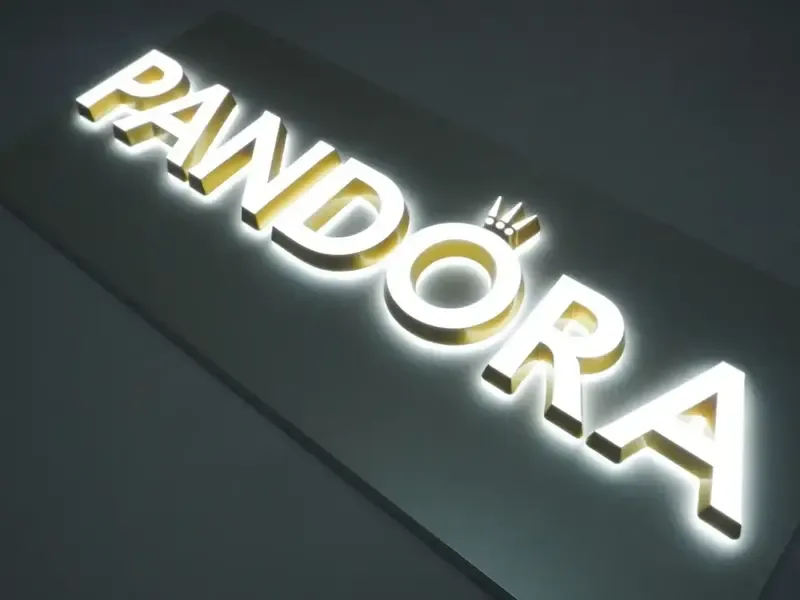 Black reverse channel letters with warm gold backlight on pub facade