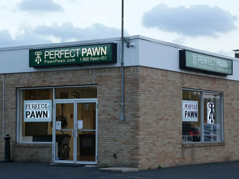 Two rectangular green cabinet signs mounted along the upper facade of a brick retail building.
