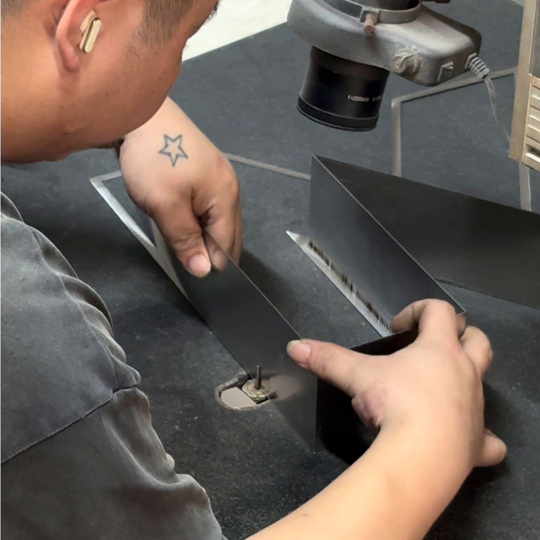 Technician laser welding metal sign returns and seams