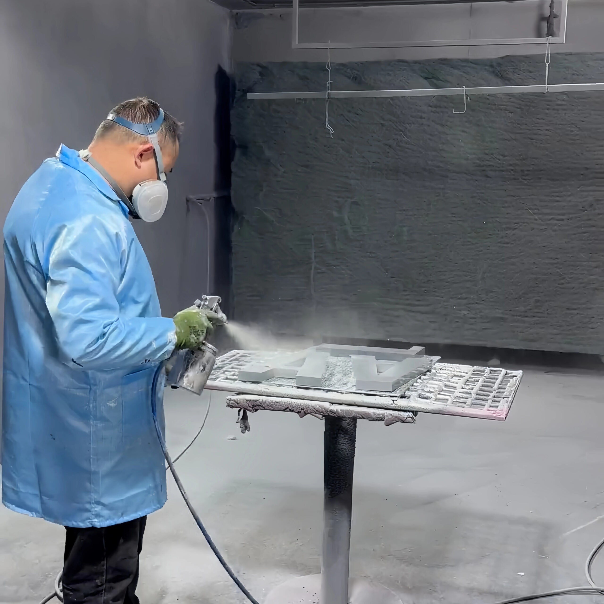 Spray finishing metal sign parts before baking and curing