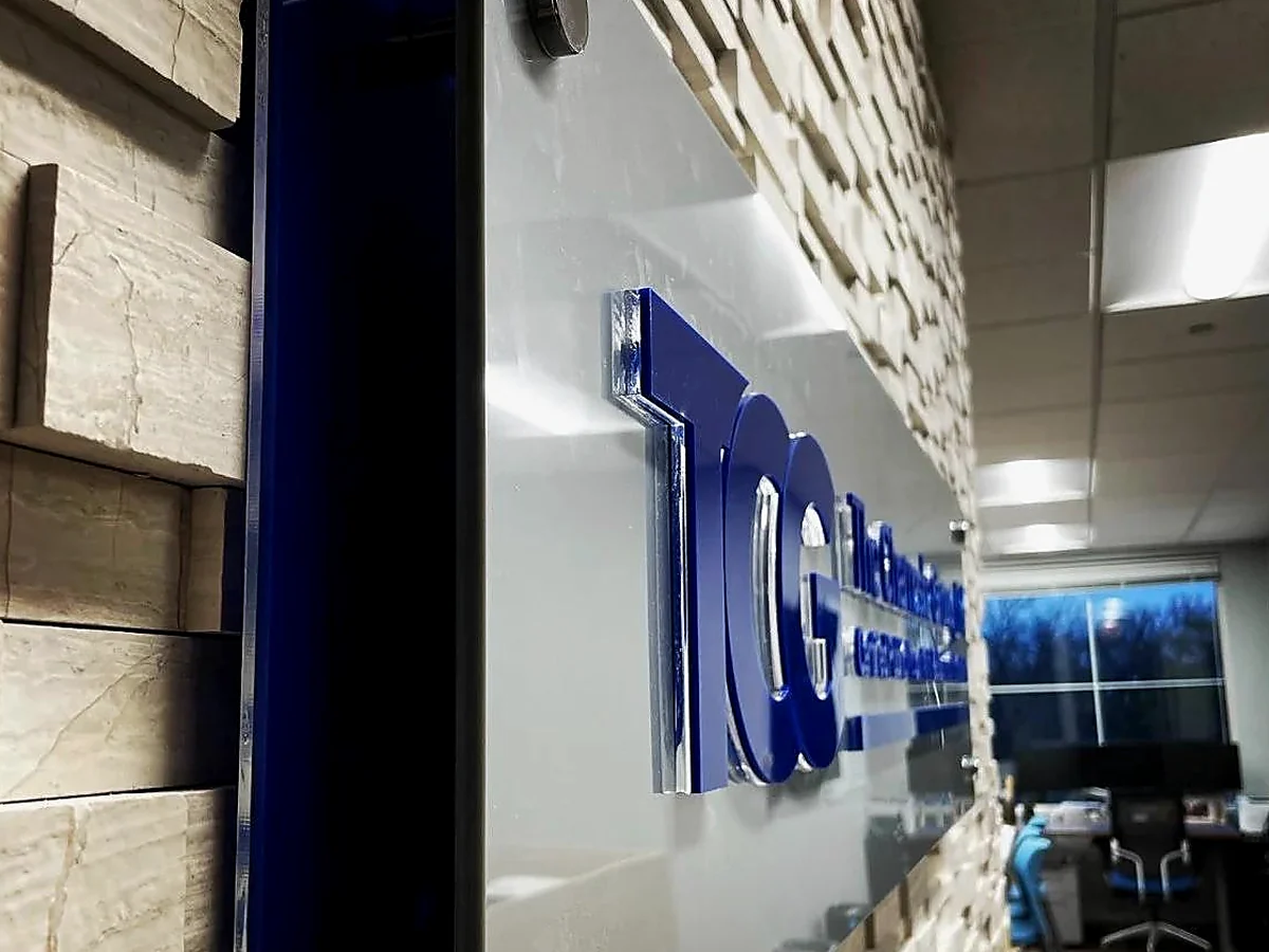 Custom dimensional acrylic logo sign installed on an office feature wall