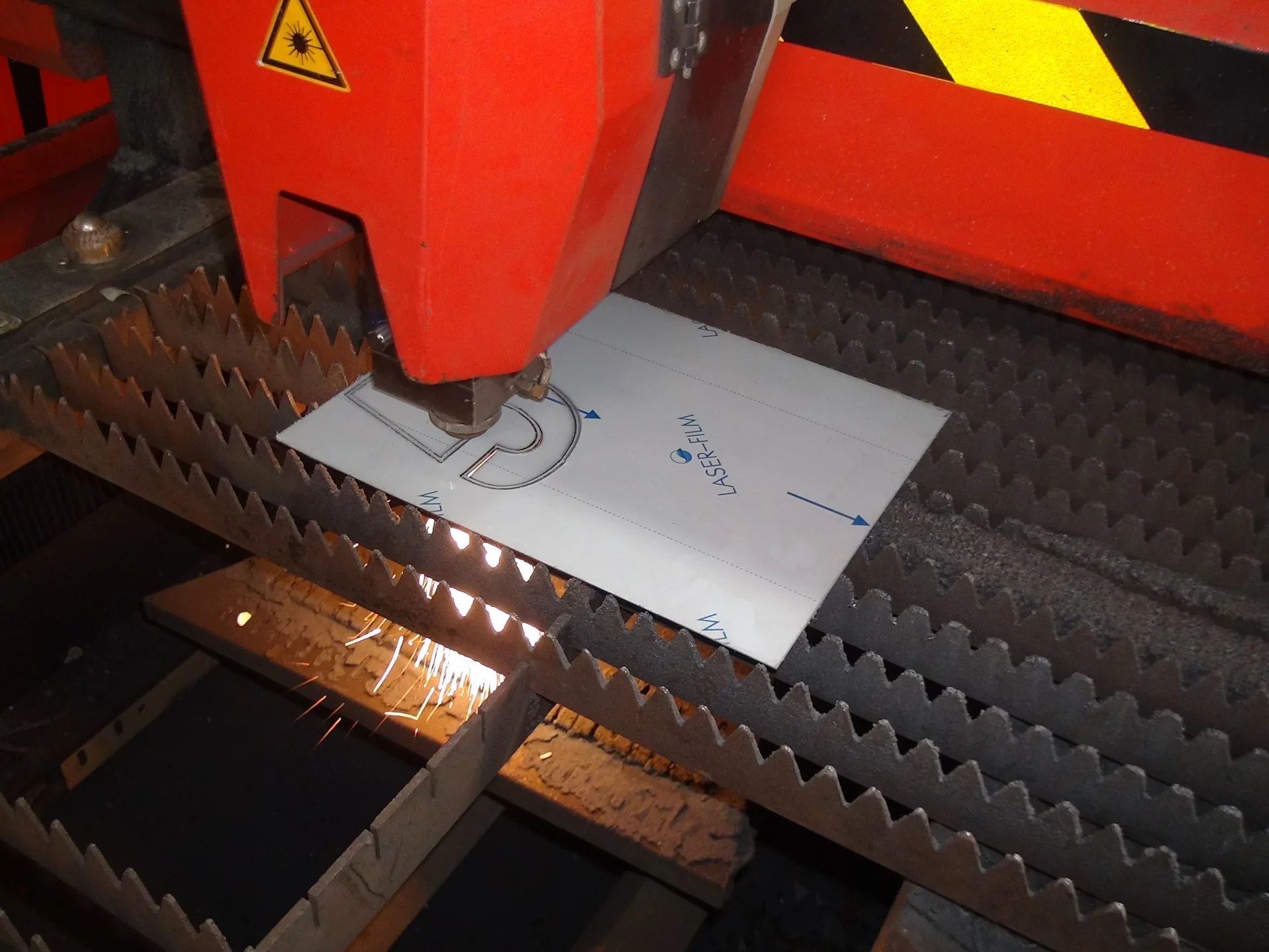 Fiber laser cutting a shaped component from sheet material