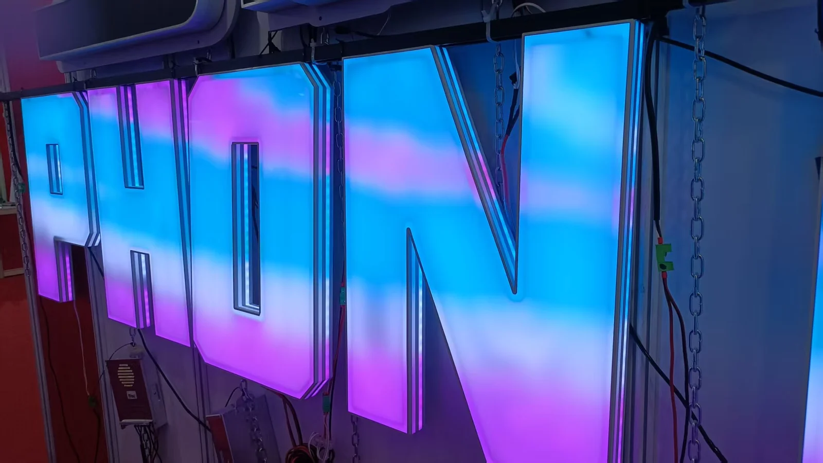 Illuminated channel letters connected to wiring on a workshop test rack