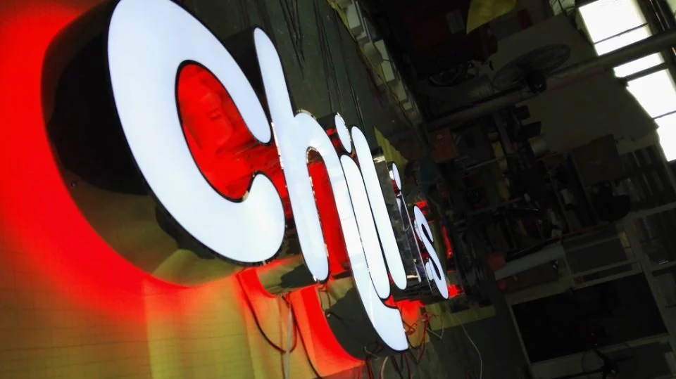 White illuminated letter faces with dark side returns and red light on the backing surface.