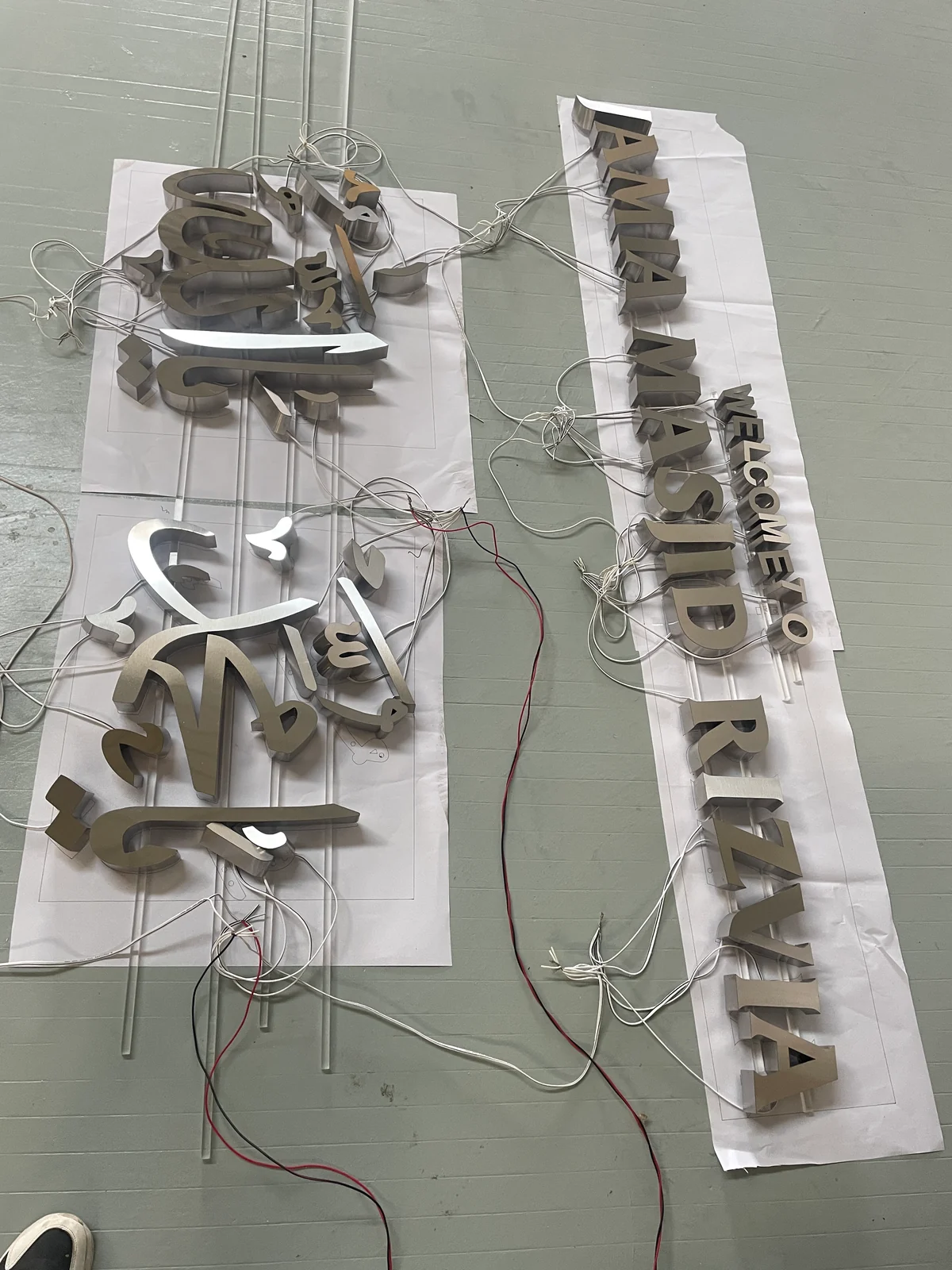Metal letter groups laid out on paper positioning references with loose power leads