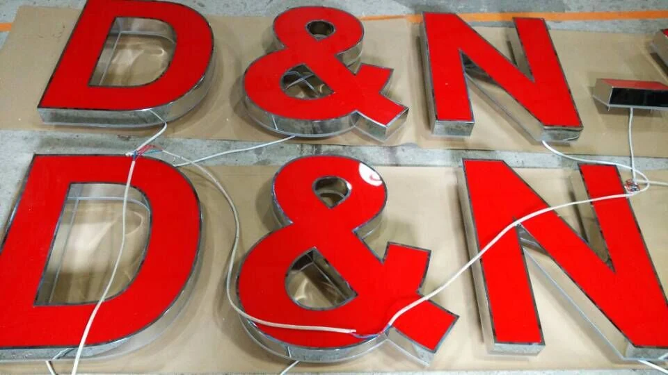 Two matching sets of red-faced channel letters arranged before installation
