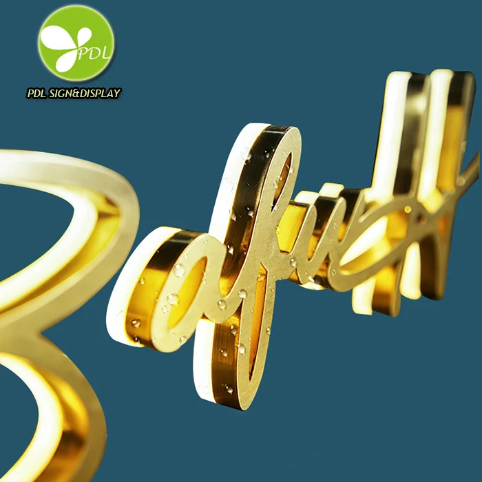 An angled view of gold-colored script lettering showing raised faces and deep side returns.
