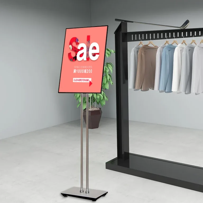 A narrow rectangular graphic display on a freestanding post beside a clothing rack.