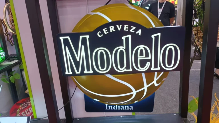 A layered round branded sign with an illuminated outline at a display area.