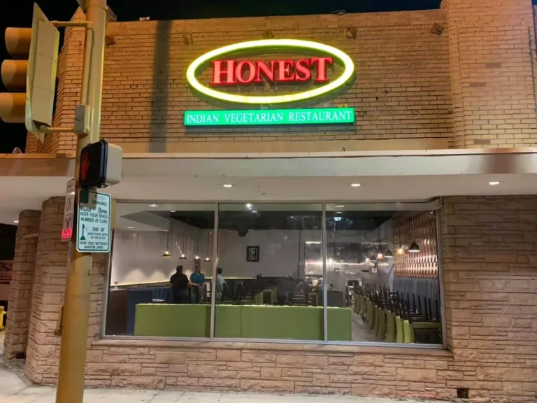 An oval illuminated sign above a brick storefront.