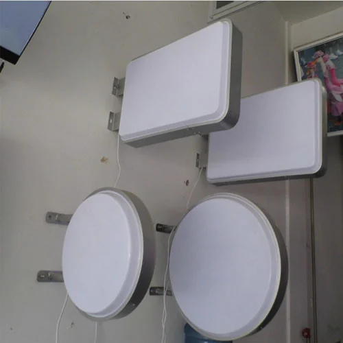 Round and rectangular projecting sign samples with plain white faces and visible wall brackets.