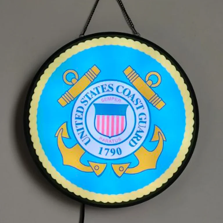 A round illuminated emblem with a blue face and yellow border.