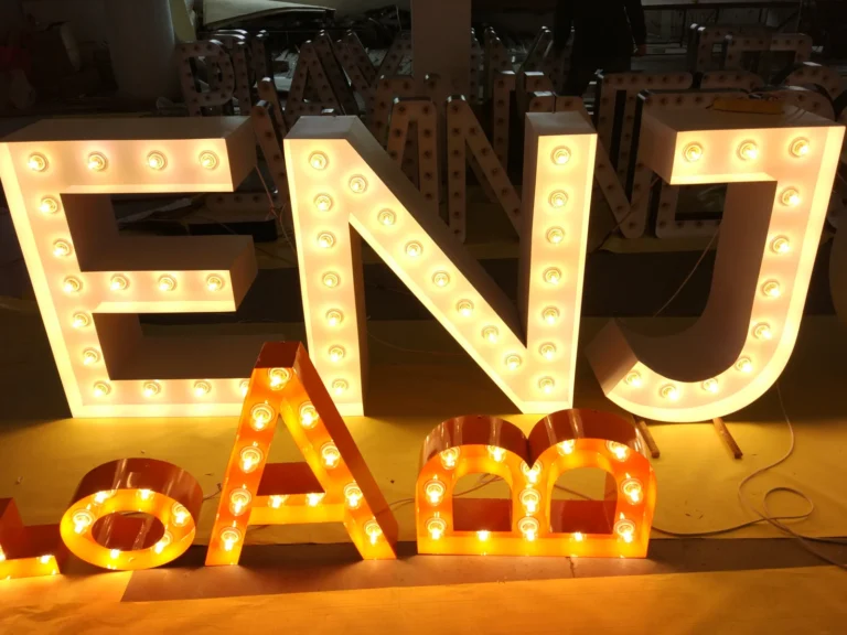 Large white ENJ letters and smaller orange letters with illuminated round bulbs.