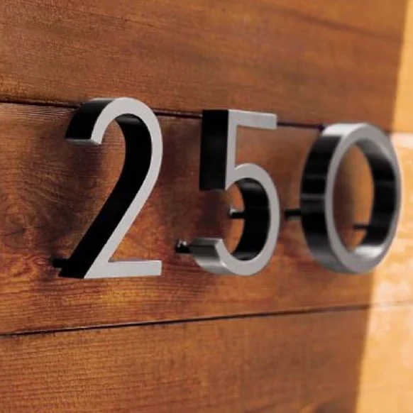 Silver-faced address numbers 250 with dark sides mounted on horizontal wood boards.