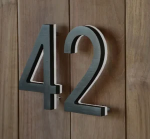 Dark dimensional address numbers 42 mounted on vertical wood boards.