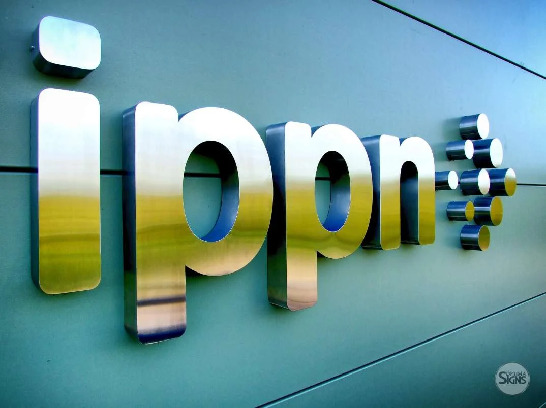 Reflective metal ipm letters and circular logo elements mounted on a panel wall
