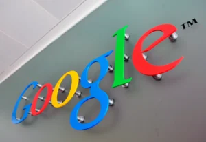 Multicolor Google lettering held away from a gray wall by visible round spacers.