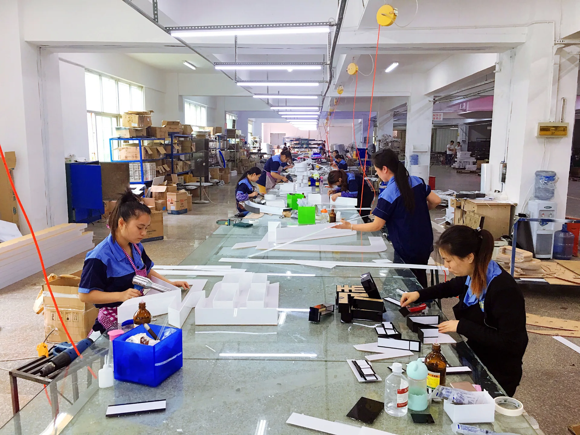 Technicians working at sign assembly tables