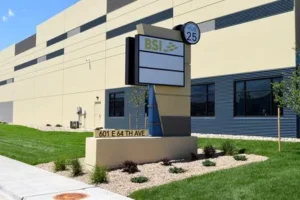 Freestanding cabinet sign mounted on a low base outside a commercial building.