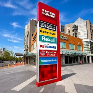 Large freestanding multi-tenant pylon sign with stacked tenant panels at a commercial complex.