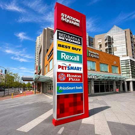 Red STATION SQUARE freestanding directory with stacked tenant panels at a commercial complex